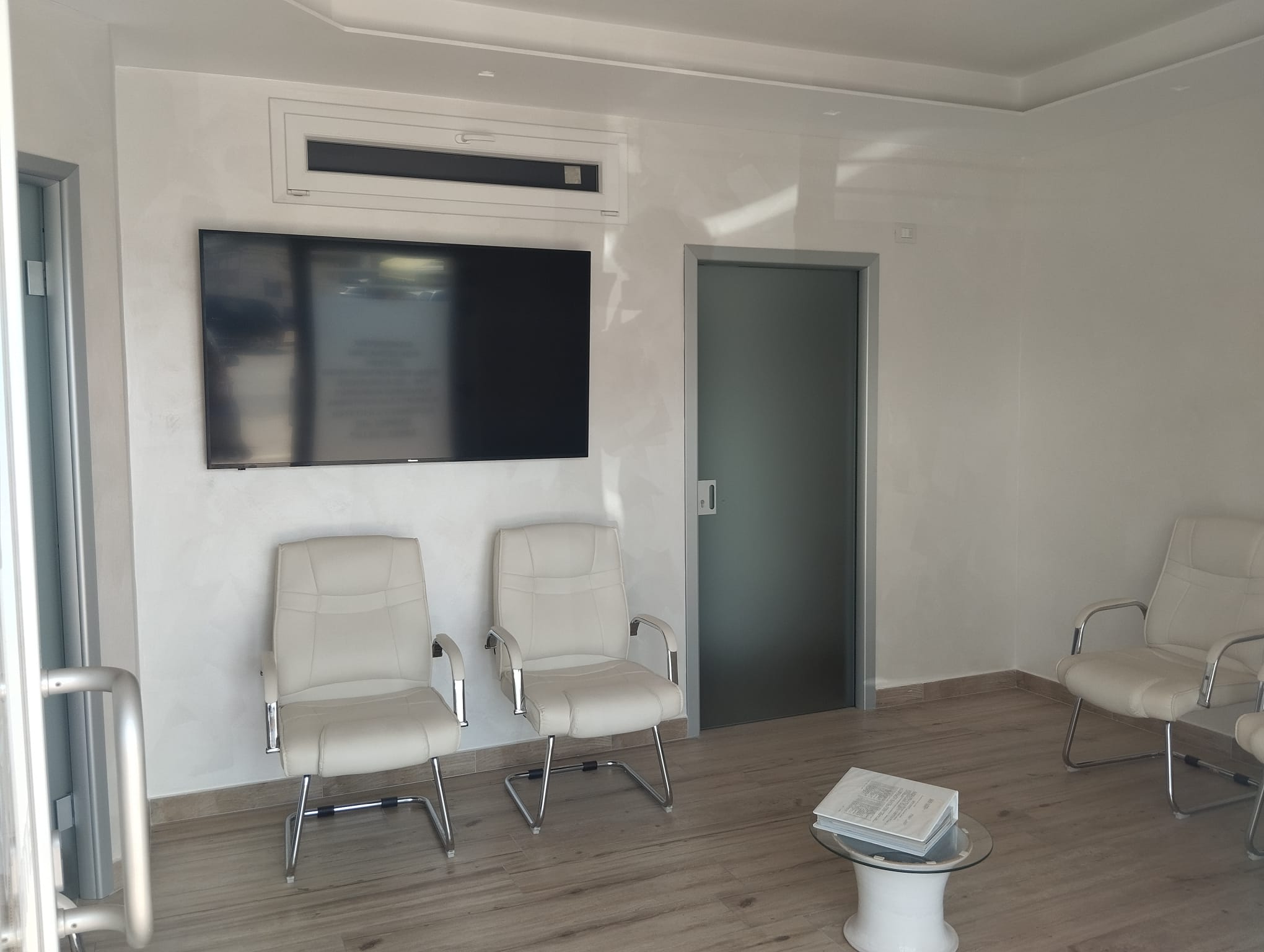 Sala d'attesa moderna con poltrone in pelle bianca